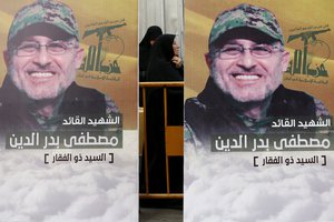 A Hezbollah supporter reacts behind fighters, pictures of slain top commander Mustafa Badreddine, who was killed in Syria, during his funeral procession in a southern suburb of Beirut, Lebanon, Friday, May 13, 2016. Lebanon's militant Hezbollah group mourned on Friday the killing in Syria of its top military commander, Mustafa Badreddine, who died in an explosion in Damascus, a death that is a major blow to the Shiite group, which has played a significant role in the conflict next door. (AP Photo/Hassan Ammar)