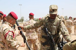 File - U.S. Army First Sgt. Gabriel Montgomery with 524th Combat Sustainment Support Battalion, 17th Sustainment Brigade, Task Force Battle Born, issues an M16 rifle to an Iraqi soldier assigned to Iraq’s 4th Battalion, 23rd Brigade, during an Iraqi Train and Equip Fund issuing point at Camp Taji, Iraq, April 16, 2016.