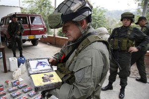 Police Col. Ricardo Alarcon shows to journalists packages containing cocaine after a raid where police say they seized half a ton of the drug