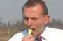 Tony Abbott bites in to a member of the onion family, possibly a spring onion, at a Queensland onion farm in 2011.