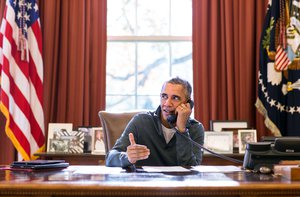 File - President Barack Obama makes Thanksgiving Day phone calls from the Oval Office to U.S. troops stationed around the world, Nov. 26, 2015.