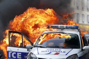 A police car burns during clashes while police forces gather to denounce the almost daily violent clashes at protests against a labor reform, Wednesday, May 18, 2016.