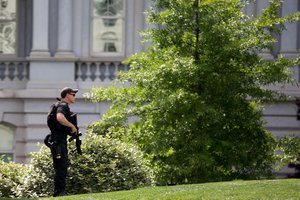 A Secret Service agent stands on the North Lawn at the White House in Washington, Friday, May 20, 2016, as the White House is placed on lockdown after there are reports of shots fired near West Executive Ave. and Pennsylvania Ave. (AP Photo/Andrew Harnik)