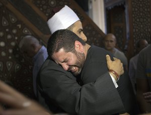 The Imam of al Thawrah Mosque, Samir Abdel Bary, gives condolences to Tarek Abu Laban, center, who lost four relatives, all victims of Thursday's EgyptAir plane crash, following prayers for the dead, at al Thawrah Mosque, in Cairo, Egypt, Friday, May 20, 2016.