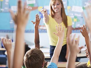 Elementary school class, raising hands