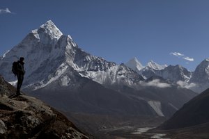 In this Sunday, Oct. 25, 2015 photo, a trekker pauses as he makes his way towards Everest Base camp, above Pheriche valley, Nepal