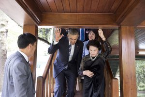 President Barack Obama ducks down under a low beam as he descends a staircase with Nguyen Thi Kim Ngan, Chairwoman of the National Assembly of the Socialist Republic of Vietnam, during a tour of Stilt House in Hanoi, Vietnam, May 23, 2016.