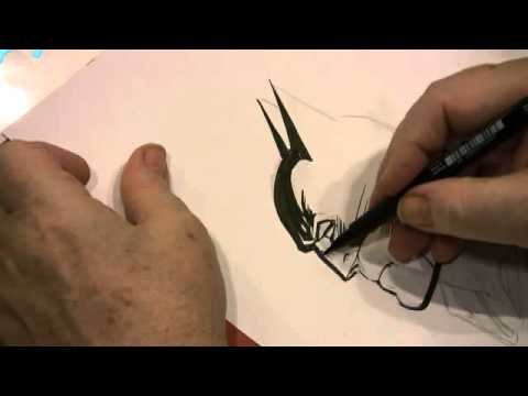 Neal Adams Drawing Batman inside a copy of the Art of Neal Adams