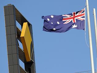 Australia's national flag flies near the corporate logo (L) above the headquarters of the Commonwealth Bank of Australia (CBA) on August 11, 2010 as the bank announced a 5.15 billion USD net profit in Sydney. The CBA posted a 20 percent increase in full year net profit but issued a cautious outlook due to global economic uncertainty. AFP PHOTO / Torsten BLACKWOOD