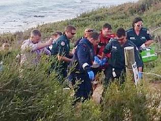 Paramedics are taking the surfer up to the waiting ambulance. A man working on him advised small children to leave. MUST CREDIT PICTURE: RACHEL FENNER, COMMUNITY NEWSPAPER GROUP.