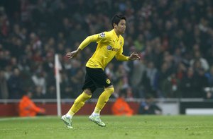 Dortmund's Shinji Kagawa runs on the pitch during the Champions League group D soccer match between Arsenal and Borussia Dortmund at the Emirates stadium in London, Wednesday, Nov. 26, 2014.