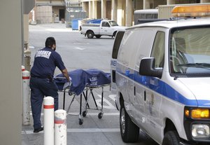 A person from the Los Angeles County Department of Medical Examiner-Coroner's office removes a body at the scene of a fatal shooting at the University of California, Los Angeles, Wednesday, June 1, 2016, in Los Angeles.