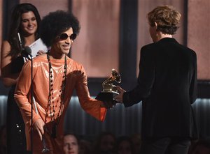 Prince, left, presents Beck with the award for album of the year for “Morning Phase”at the 57th annual Grammy Awards on Sunday, Feb. 8, 2015, in Los Angeles