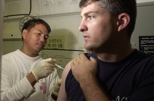 Hospital Corpsman 1st Class Al Paraguyn from Cebuity, Philippines, assigned to the Mighty Shrikes of Strike Fighter Squadron Nine Four (VFA-94), updates numerous vaccines for fellow squadron members