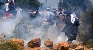 Protestors in Ni'lin running away from tear gas