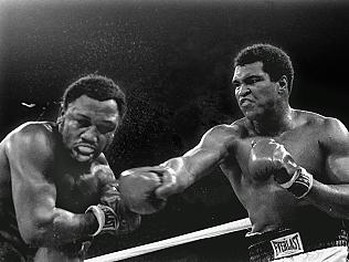 Boxing - in this 01 Oct 1975 file photo, spray flies from the head of challenger Joe Frazier, left, as heavyweight champion boxer Muhammad Ali connects with a right in the ninth round of their title fight in Manila, Philippines.(AP Photo/Mitsunori Chigita, File)