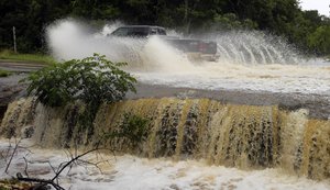 A motorist passes through a low-water crossing on a road closed due to high water near New Braunfels, Texas, Thursday, June 2, 2016.