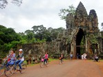 Locals and tourists ride bicycles at the South Gate of Baphuon in Angkor, Siem Reap.