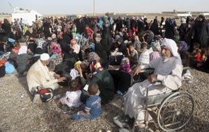 Iraqi families gather outside an Iraqi army military Camp near Fallujah, Iraq, Friday, June 3, 2016, after being displaced during fighting between Iraqi security forces and the Islamic State group during a military operation to regain control the city.