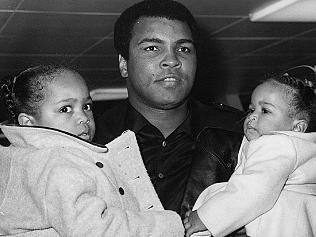 FILE - In this Dec. 20, 1978, file photo, World heavyweight champion Muhammad Ali carries his daughters, 2-year-old Hana, left, and nine-month-old Laya at London's Heathrow Airport. Ali, the magnificent heavyweight champion whose fast fists and irrepressible personality transcended sports and captivated the world, has died according to a statement released by his family Friday, June 3, 2016. He was 74.(AP Photo/File)