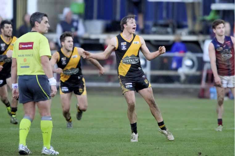 Kyneton's Bryce Hinneberg, a back pocket who has barely kicked a goal all season, is on the verge of glory as he kicks to win after the final siren in the BFL match against Sandhurst. Picture: Shawn Smits.