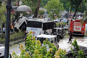 Turkish security officials and firefighters work at the explosion site after a bus carrying riot police official was struck by a bomb in Istanbul, Tuesday, June 7, 2016. At least five police officers were wounded. The blast occurred at a busy intersection near an Istanbul University building in the city’s Beyazit district during the morning rush hour. (DHA via AP) TURKEY OUT