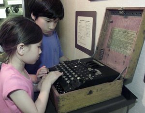 Ally Sage, 6, and Daniel Sage,11, try a working Enigma machine, used by the Nazis in World War II to send coded messages, at a display at the National Cryptologic Museum, which is funded by the National Security Agency, at Fort Meade, Md., June 25, 2002.