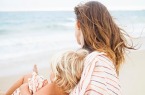 Back view of mother and child wrapped in striped towel