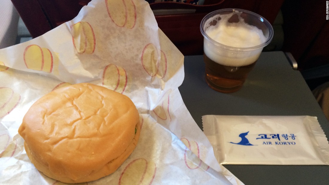 The inflight meal consists of a burger and glass of North Korean beer.