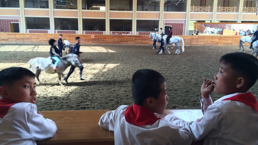 North Korean students watch horse riding lessons at a new equestrian center designed by Supreme Leader Kim Jong Un. The facility was formerly used for military training.