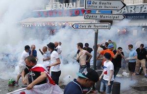 England supporters take evasive action after French police fired tear gas at them in downtown Marseille, France, Friday, June 10, 2016.