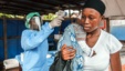 FILE - A woman has her temperature taken as part of Ebola prevention, prior to entering the Macauley government hospital in Freetown, Sierra Leone, Jan. 21, 2016.  