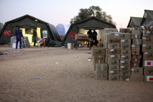 File - A depot for aid supplies in a transit camp on the Libya-Tunisia border. The supplies will go toward assisting the thousands of refugees arriving at the camp from Libya, where a violent political crisis rages on, 5 March, 2011.