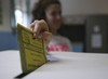 A woman casts her ballot for a referendum on the duration of offshore drilling concessions, in Pavia, Italy, Sunday, April 17, 2016