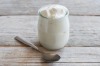 Jar of fresh greek yogurt on a wooden table