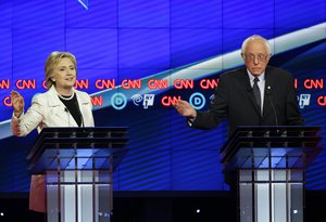 File - Democratic presidential candidate Sen. Bernie Sanders, I-Vt., right, gestures while Hillary Clinton speaks during the CNN Democratic Presidential Primary Debate at the Brooklyn Navy Yard Thursday, April 14, 2016, New York.