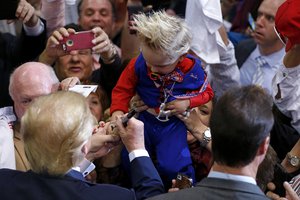 Republican presidential candidate Donald Trump signs the hand Curtis Ray Jeffrey II, of Bluff Creek, La., whose hair was stylized to resemble Trump's, at a campaign rally in Baton Rouge, La., Thursday, Feb. 11, 2016.