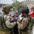 Israeli soldiers stop Palestinians at the entrance of Yatta near the West Bank city of Hebron June 9, 2016. The Israeli army entered the village in search for clues leading to an attack the previous night in the Israeli city of Tel Aviv in which four people were killed and 16 others wounded. The two Palestinians assailants who carried out the attack came from Yatta, according to Israeli authorities. Israel said it had suspended entry permits for 83,000 Palestinians during the holy Muslim month of Ramadan following the shooting attack. Photo by Wisam Hashlamoun