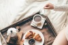 Woman having breakfast in bed. Window light