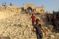 People walk through the rubble of the Prophet Younis Mosque in the city of Mosul. According to an opinion poll, support ...