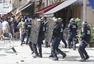 French police officers charge soccer supporters during clashes in downtown Marseille, France, Saturday, June 11, 2016.