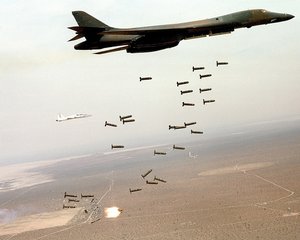 File - A B-1B Lancer unleashes cluster munitions. The B-1B uses radar and inertial navigation equipment enabling aircrews to globally navigate, update mission profiles and target coordinates in-flight, and precision bomb without the need for ground-based navigation aids.