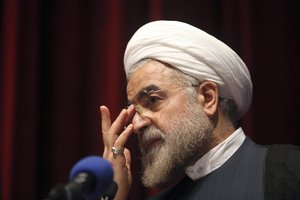 File - Iran's former nuclear negotiator, Hasan Rohani, a potential front-runner in presidential race, adjusts his glasses during a campaign rally in Tehran, Iran, Thursday, April 11, 2013.