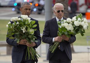 President Barack Obama with Vice President Joe Biden carry bouquets comprised of a total of 49 white roses, one in honor of each of the deceased victims, as they visit a memorial to the victims of the Pulse nightclub shooting, Thursday, June 16, 2016 in Orlando, Fla