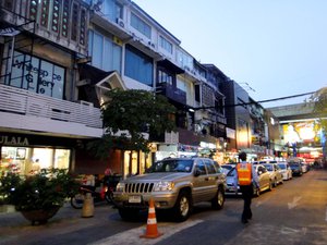 A police patrols a Bangkok street come dusk time.