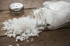 Spilled salt with salt shaker on wooden background