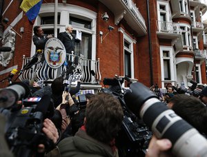 WikiLeaks founder Julian Assange holds a U.N. report as he speaks on the balcony of the Ecuadorean Embassy in London, Friday, Feb. 5, 2016.