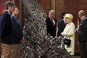 Britain's Queen Elizabeth looks at the Iron Throne as Prince Philip (R) talks to cast member Rose Leslie on the set of the television series Game of Thrones, in the Titanic Quarter of Belfast, Northern Ireland, June 24, 2014. Also pictured are Game of Thrones cast members Kit Harington (4th R), Conleth Hill (5th R) and Lena Headey (6th R). REUTERS/Jonathan Porter/Pool (NORTHERN IRELAND - Tags: ROYALS ENTERTAINMENT SOCIETY)