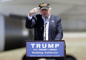 Donald Trump, the presumptive Republican presidential nominee  gestures to a his camouflaged "Make America Great" hat as he discuses his support by the National Rifle Association at a campaign rally at the Redding Municipal Airport Friday, June 3, 2016, in Redding, Calif.