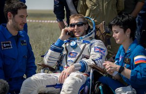 Tim Peake of the European Space Agency talks on a satellite phone in a chair outside the Soyuz TMA-19M spacecraft just minutes after he and Yuri Malenchenko of Roscosmos and Tim Kopra of NASA landed in a remote area near the town of Zhezkazgan, Kazakhstan on Saturday, June 18, 2016.